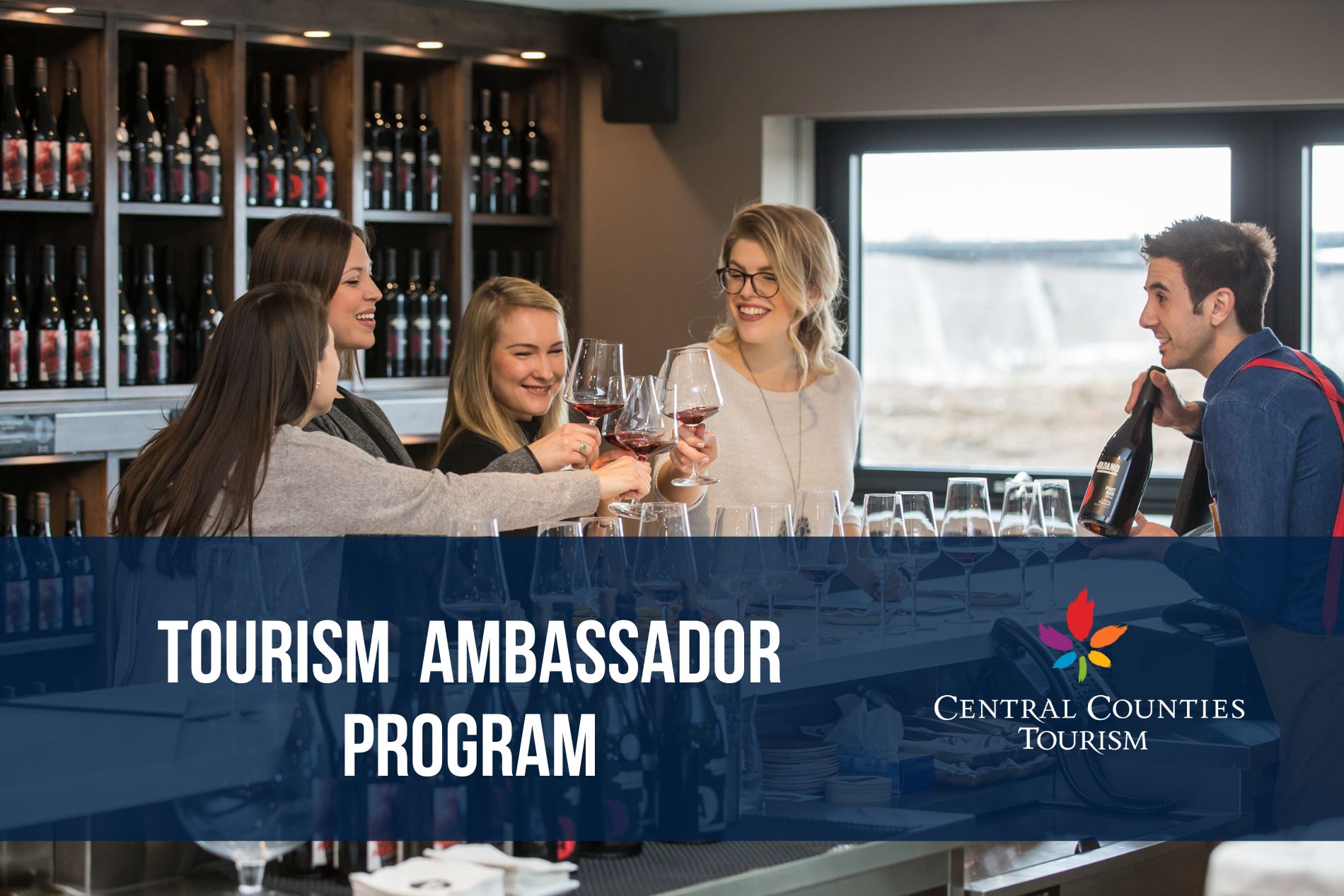 Four ladies doing a 'cheers' with glasses of wine. Ad for the Tourism Ambassador Program