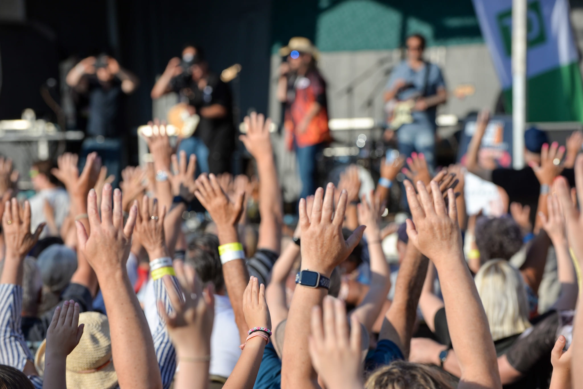 A crowd with their hands in the air at a concert.