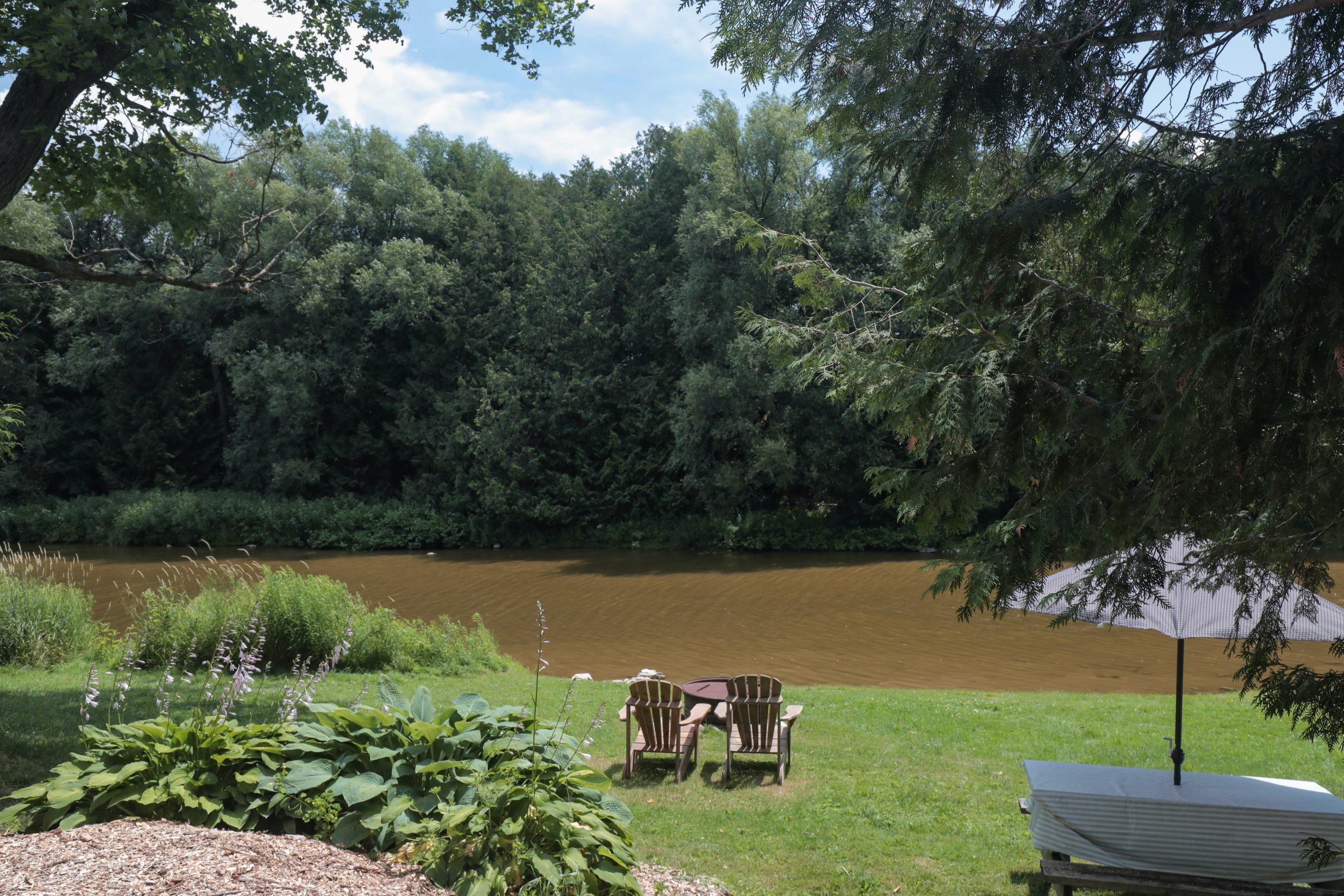 Two Adirondack chairs overlook the water at the Harmony Resorts.