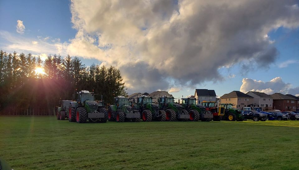 A row of tractors in the sunset