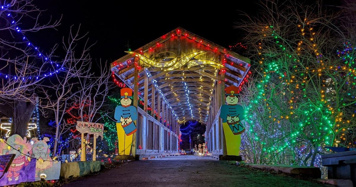 a bright lit pathway with lights and decorations