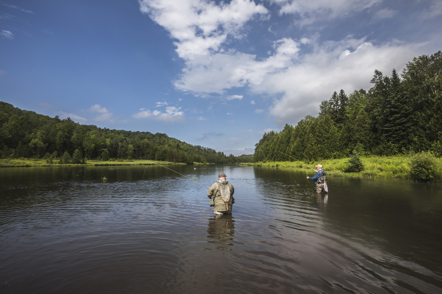 two men fly-fishing in pine river in the water